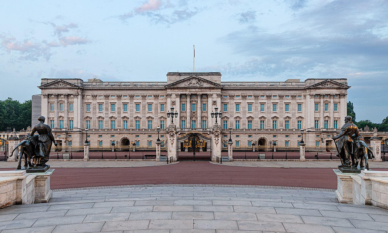 The east front of Buckingham Palace, seen across the forecourt at dusk.